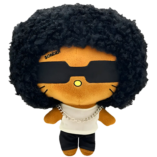 THE SONDER R&B plush collectible — soft sculpture with high-volume curly hair, matte-black eyewear and silver Cuban link chain